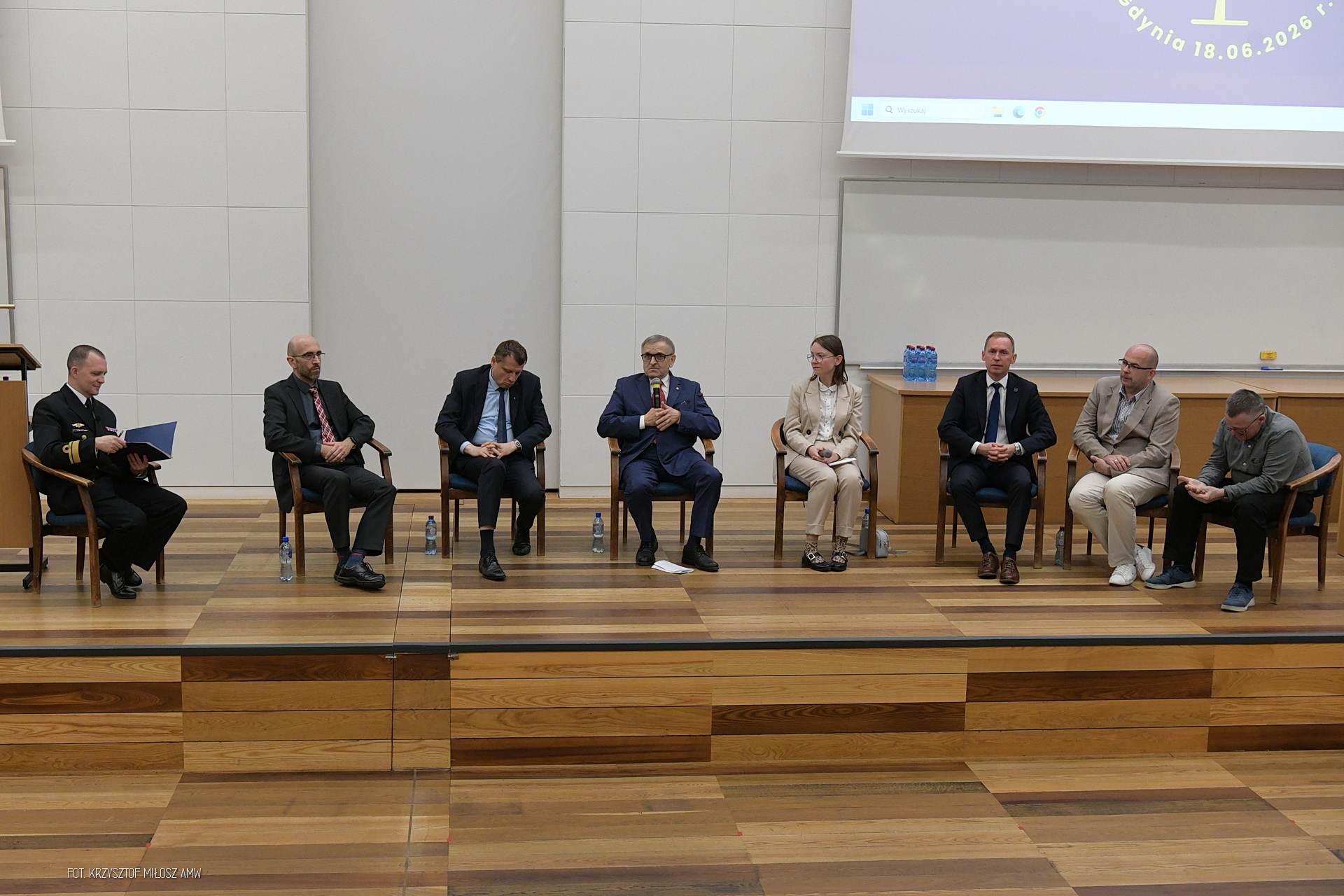 B.Ceran oraz D. Złotecka podczas panelu dyskusyjnego, na zdjęciu widoczne jeszcze 6 innych osób siedzących na krzesłach w półkolu