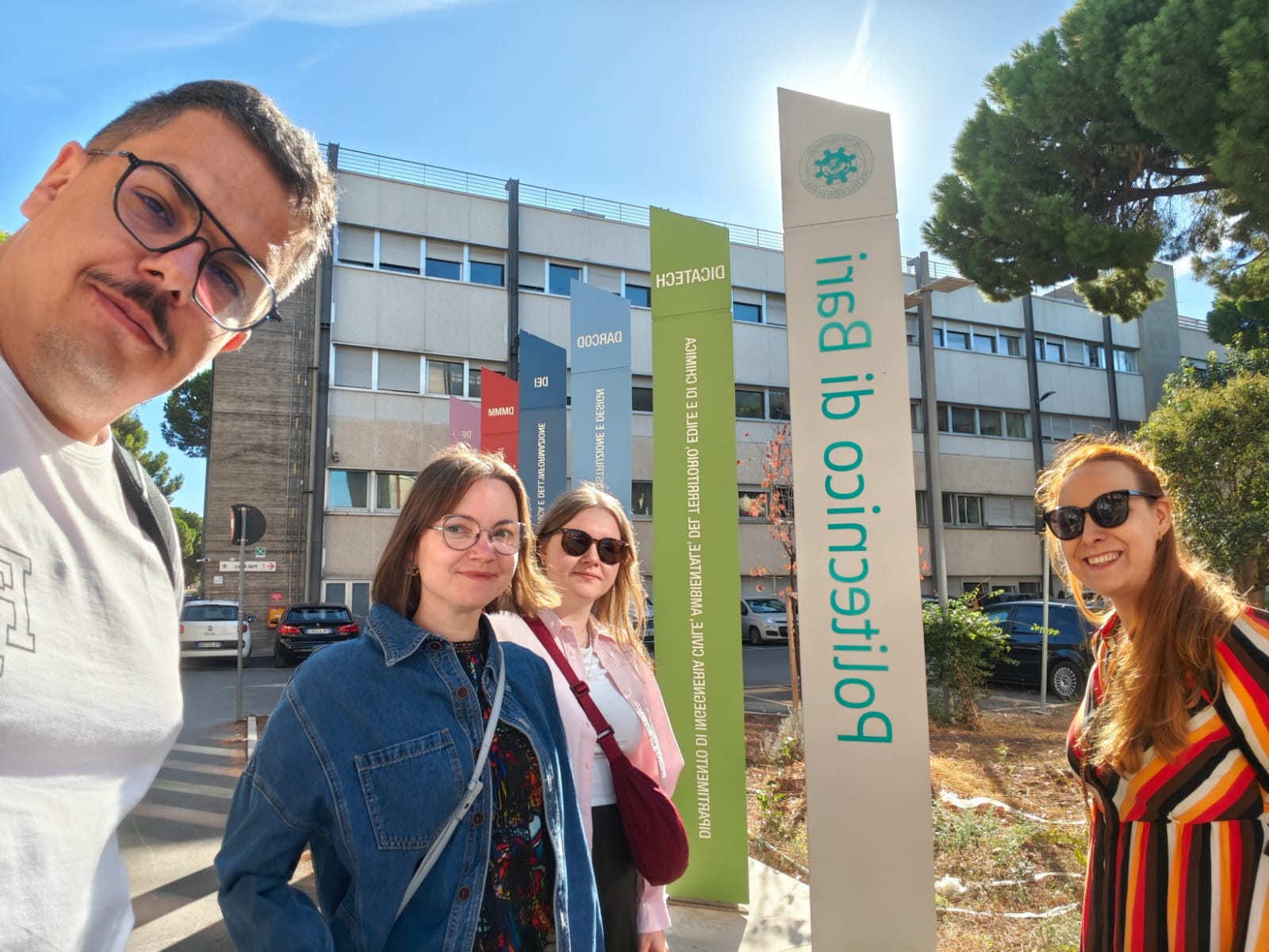 zdjęcie przedstawiające 4 osoby (pracownicy IE) przed budynkiem Politecnico di Bari