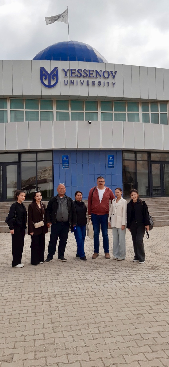 zdjęcie przedstawiające dr inż. B. Olejnika z innymi osobami na tle budynku Yessenov University w Aktau (Kazachstan)